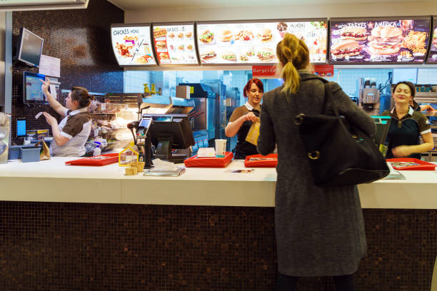 The girl receives an order in the interior of the McDonald's, Munich, Germany Munich, Germany - October 24, 2017: The girl receives an order in the interior of the McDonald's fast-food restaurant fast food stock pictures, royalty-free photos & images