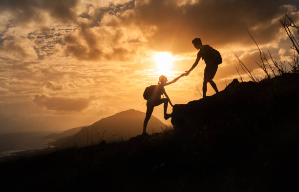 日の出山をそれぞれ他のハイキングを助ける人々。 - outdoors exercising climbing motivation ストックフォトと画像