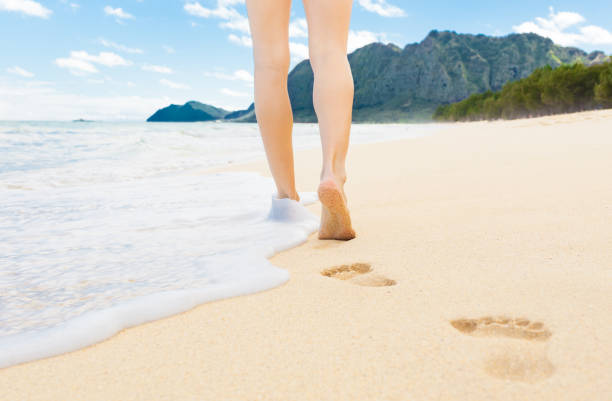 istock Woman walking on the beach 977818082