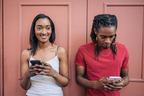 istock Young African American couple using phones 977824106