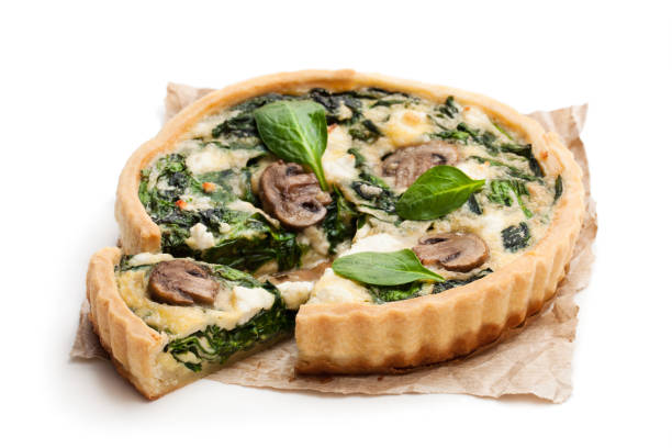 istock Traditional  french quiche pie with spinach and mushroom isolated on white 977830578