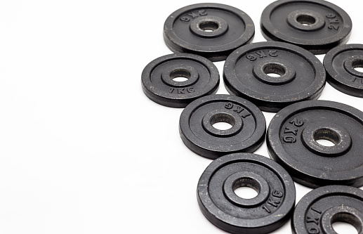 Black metal weights 1kg and 2kg on white background.