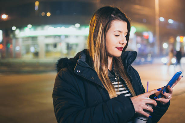 istock Young woman walking the city at night 977916792