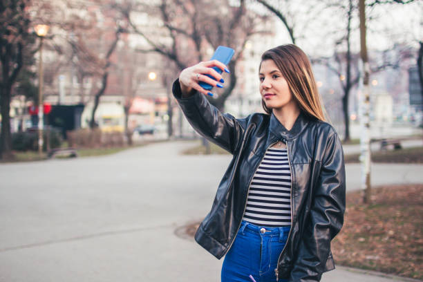 istock Beautiful young woman taking selfie 977924424