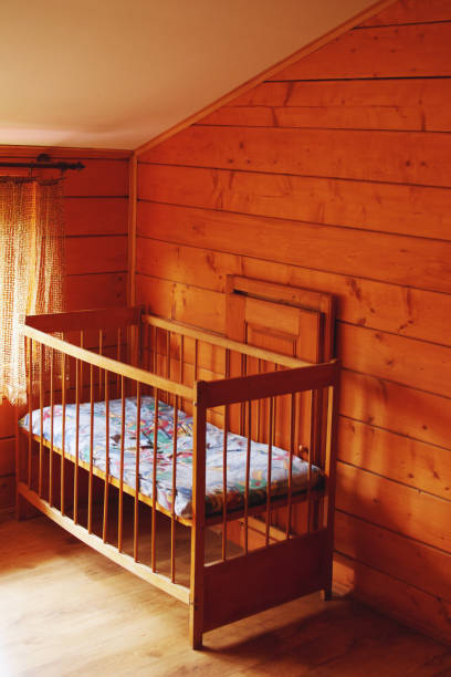 istock Empty baby crib in the room near the window 977946526