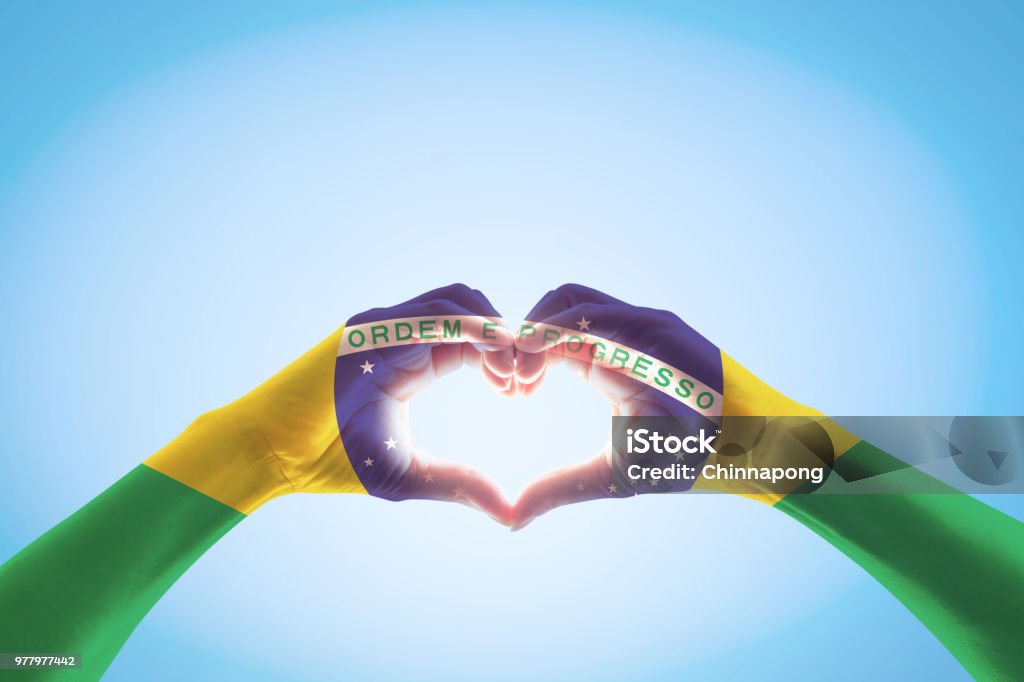 Brazil flag on people hands in heart shape for labor day and national holiday celebration isolated on blue sky background Brazil Stock Photo