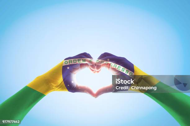 Brazil Flag On People Hands In Heart Shape For Labor Day And National Holiday Celebration Isolated On Blue Sky Background Stock Photo - Download Image Now