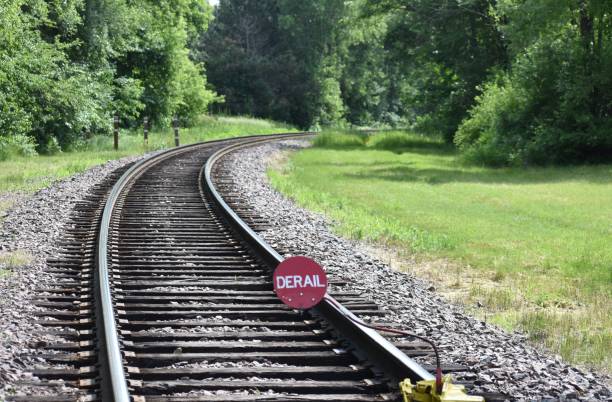 istock Derail Sign on Railroad Track Entering Woods Around a Bend 978012548