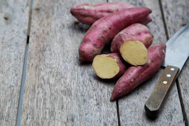 istock Raw sweet potatoes on wood background 978022770
