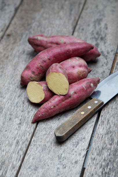 istock Raw sweet potatoes on wood background 978022944