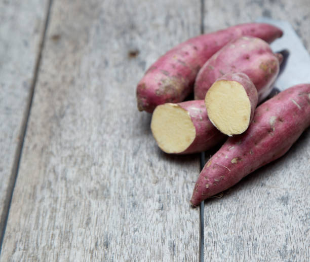 istock Raw sweet potatoes on wood background 978023012