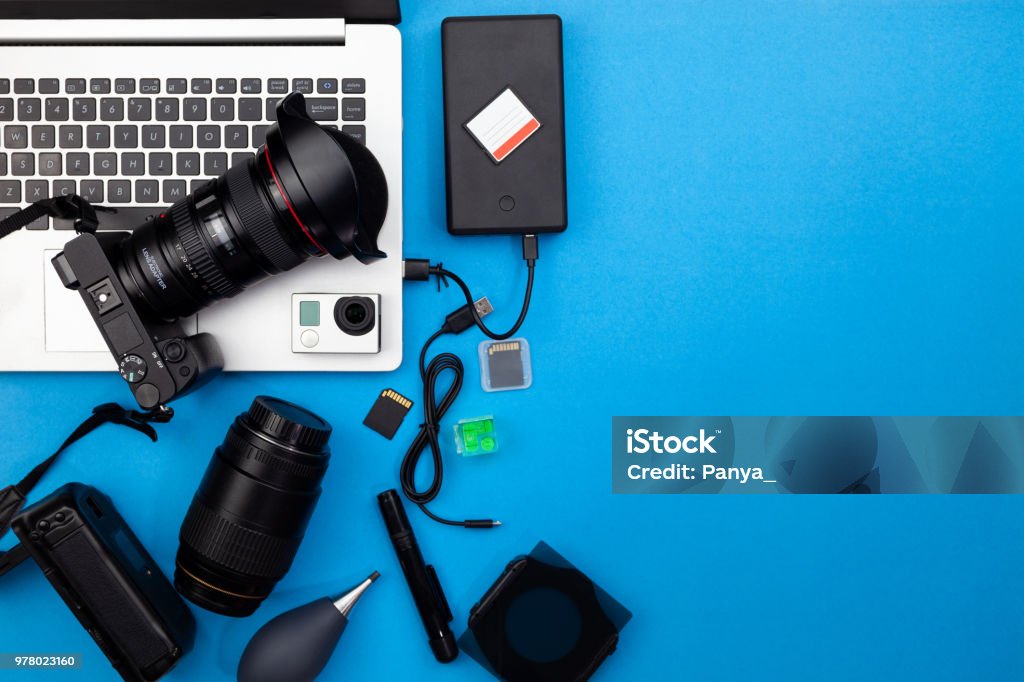 Digital camera with lenses and equipment of the professional photographer on blue paper background. Digital camera with lenses and equipment of the professional photographer on blue paper background Computer Stock Photo