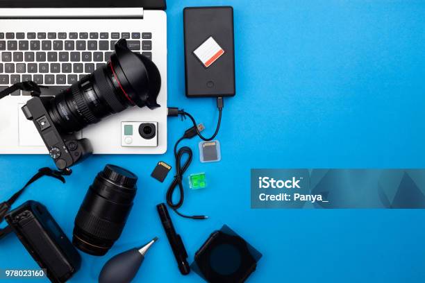 Digital Camera With Lenses And Equipment Of The Professional Photographer On Blue Paper Background Stock Photo - Download Image Now