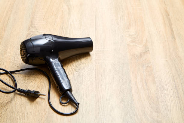 istock black hair dryer on wood background. 978023638