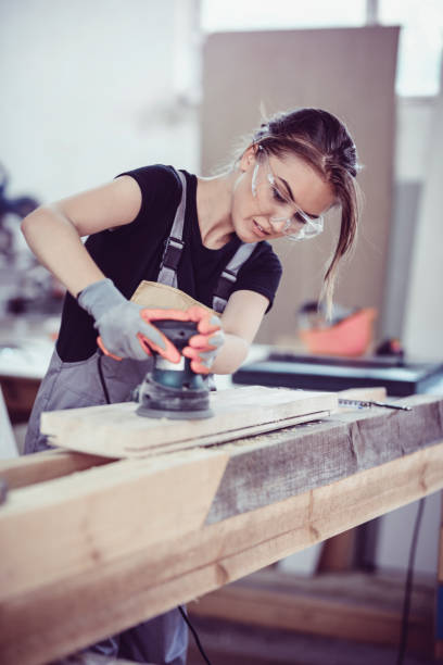 istock Cute Female Carpenter Preparing Wood For Manufacturing 978036356