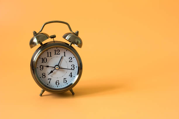 istock alarm clock on orange background and copy space and write space for write text or message / time concept 978066262