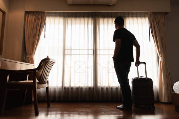 istock man holding luggage in the hotel 978183676