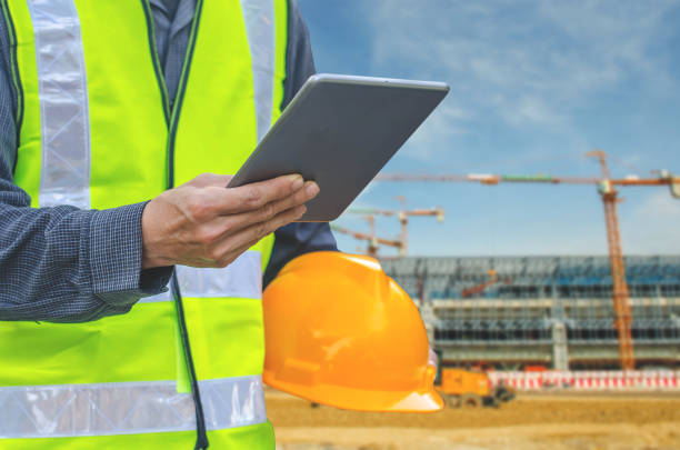 istock Closeup image with male hand hold and touch screen with sending text on smart phone, tablet,cellphone over blurred Construction site background. 978203296