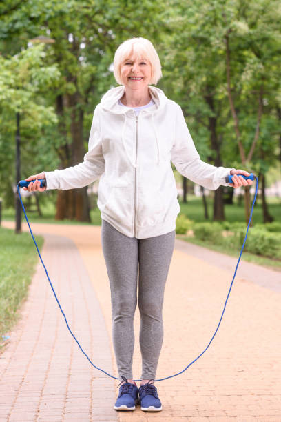 istock senior sportswoman training with jump rope in park 978215406