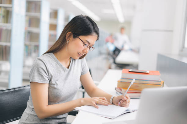 istock Asian Woman writing in the library. 978223296
