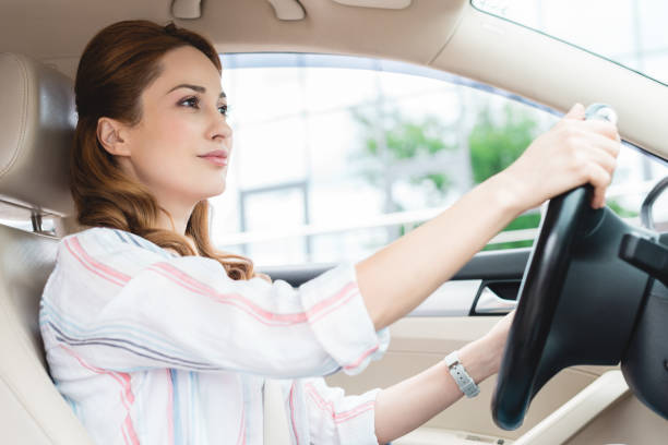 istock side view of attractive woman driving car alone 978238614