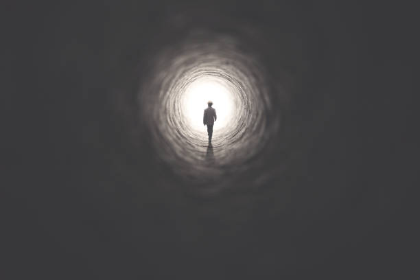 istock man getting out of a dark tunnel toward light 978249378