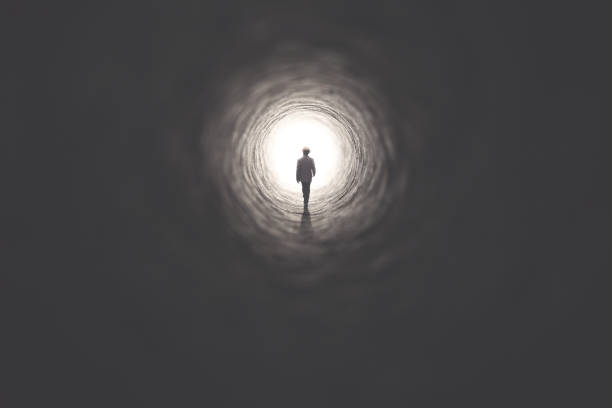 man getting out of a dark tunnel toward light - way out sign imagens e fotografias de stock