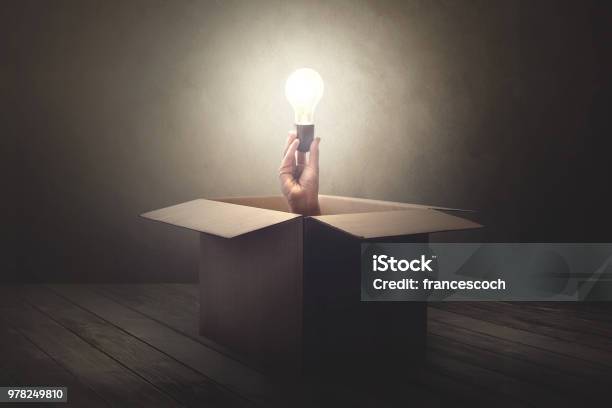 Han Holding Light Bulb Coming Out From A Paper Box Stock Photo - Download Image Now - Solution, Box - Container, Delivering