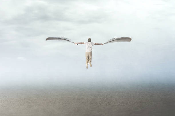 man with plumes wings fly in the sky stock photo