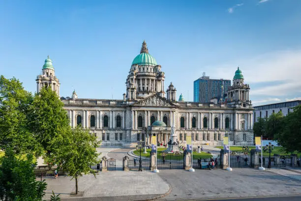 View from above towards the Belfast City Hall in summer under sunny blue sky. Edited with unrecognizable people, removed and retouched all logos and trademarks. Belfast, Northern Ireland, United Kingdom.