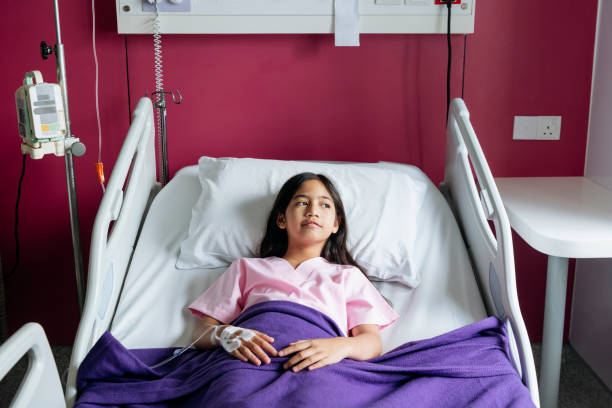 istock Asian girl in hospital bed with pensive expression 978265046