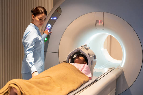 istock Young girl lying down in preparation for MRI scan 978265120