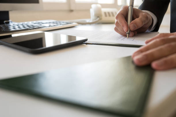 istock Businessman signing document at his office table in a low angle view 978267750