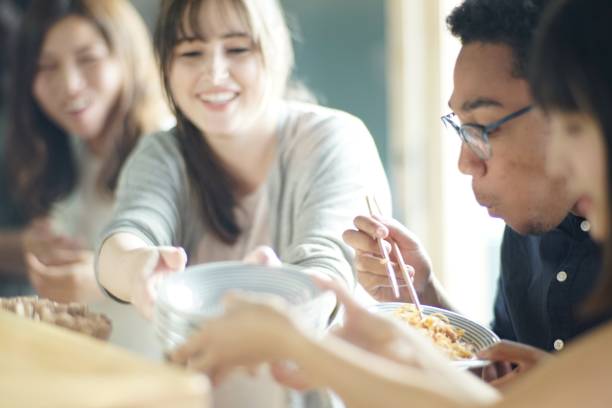 verschiedenen ethnischen freunde genießen ein abendessen im japanischen pub - eating men food chopsticks stock-fotos und bilder