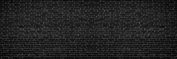 istock Wide black brick wall - spacious dark old masonry background 978268506