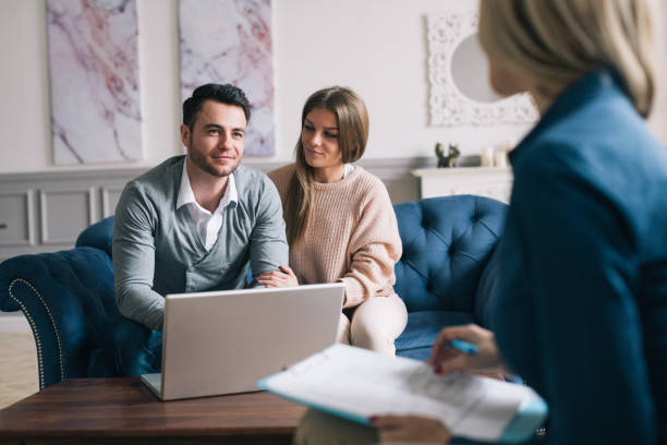 istock Happy couple planning their future while consulting with insurance agent in their home. 978277092