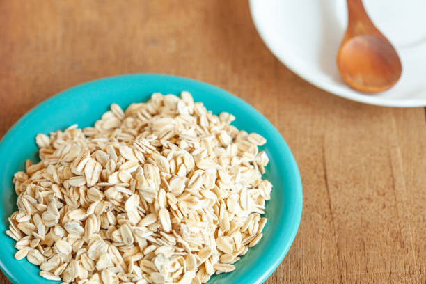 istock Oats flakes in dish on wood table 978285472