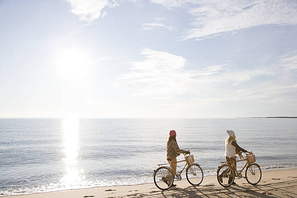 femmes au bord de la mer avec des vélos - cape cod national seashore photos et images de collection