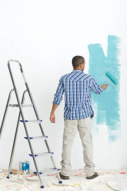 uomo dipinto muro - uomo dipinge foto e immagini stock