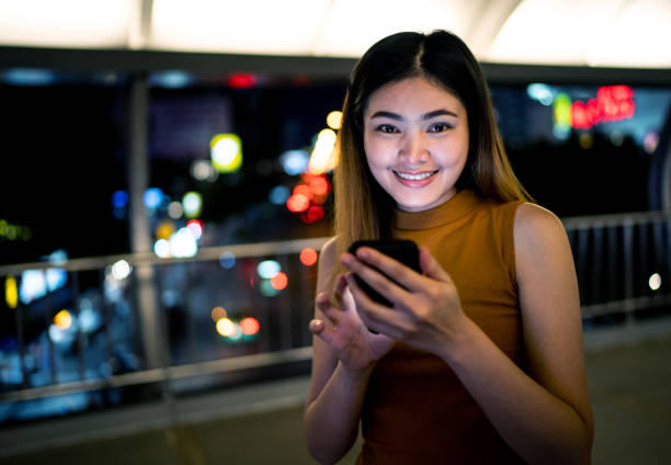 istock She was walking and playing mobile phone on the sky walk, at night 978301872