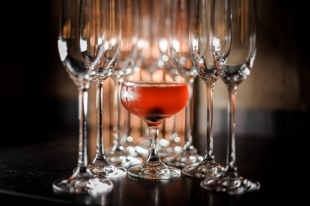 istock Glass filled with tasty red summer alcoholic drink with empty champagne glasses 978308452