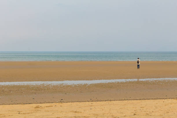 istock Woman walking along the beach 978314376