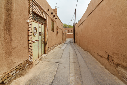 Narrow street with of old adobe Yazd city. Iran