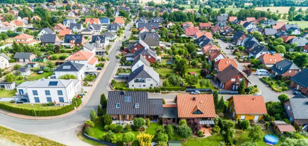 Photo of Typical German new housing development in the flat countryside of northern Germany between a forest and fields and meadows