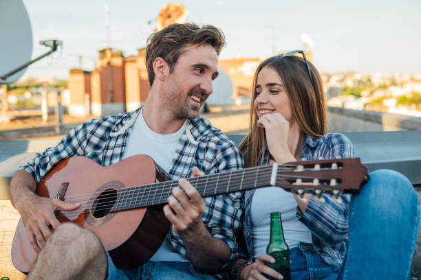 istock Handsome man playing guitar on the roof 978333190