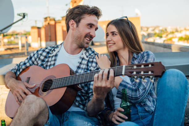 istock Happy couple with acoustic guitar on rooftop 978335686