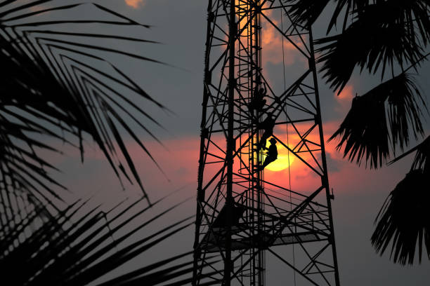 istock Workers are climbing to repair the telecommunication tower,Red sky sunset background 978336418