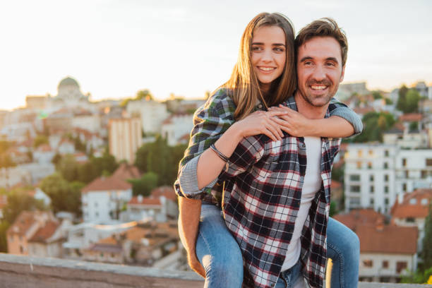 istock Smiling young couple piggyback riding on the roof 978340206