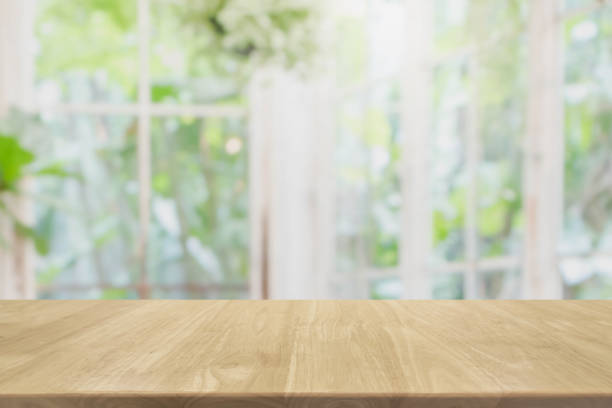 istock Empty wood table top and blurred of interior room with window view green from tree garden background background - can used for display or montage your products. 978357228