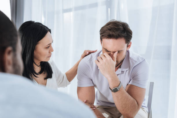 istock selective focus of mature asian woman supporting crying man during group therapy 978367520